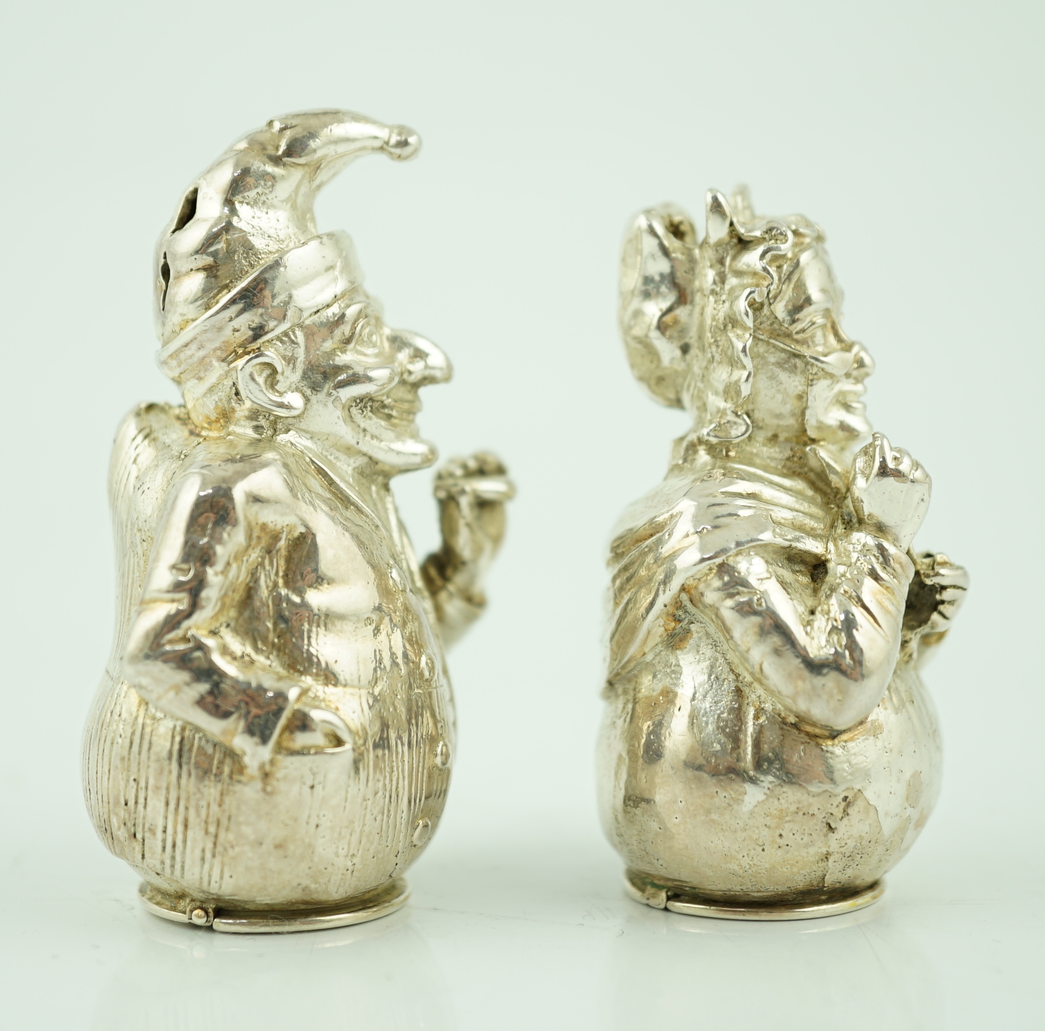 A pair of cast late Victorian novelty silver pepperettes, modelled as Punch and Judy, Edward H. Stockwell